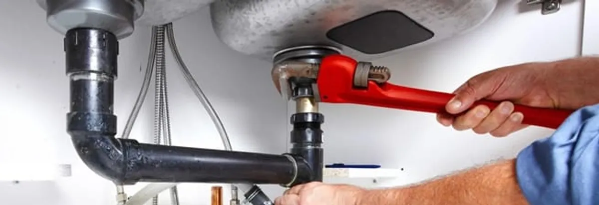 Garbage disposal repair technician tightening the sink drain and disposal connection in Worcester, MA