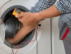 Washing machine repair technician testing a front-load washer with diagnostic tools in Worcester, MA